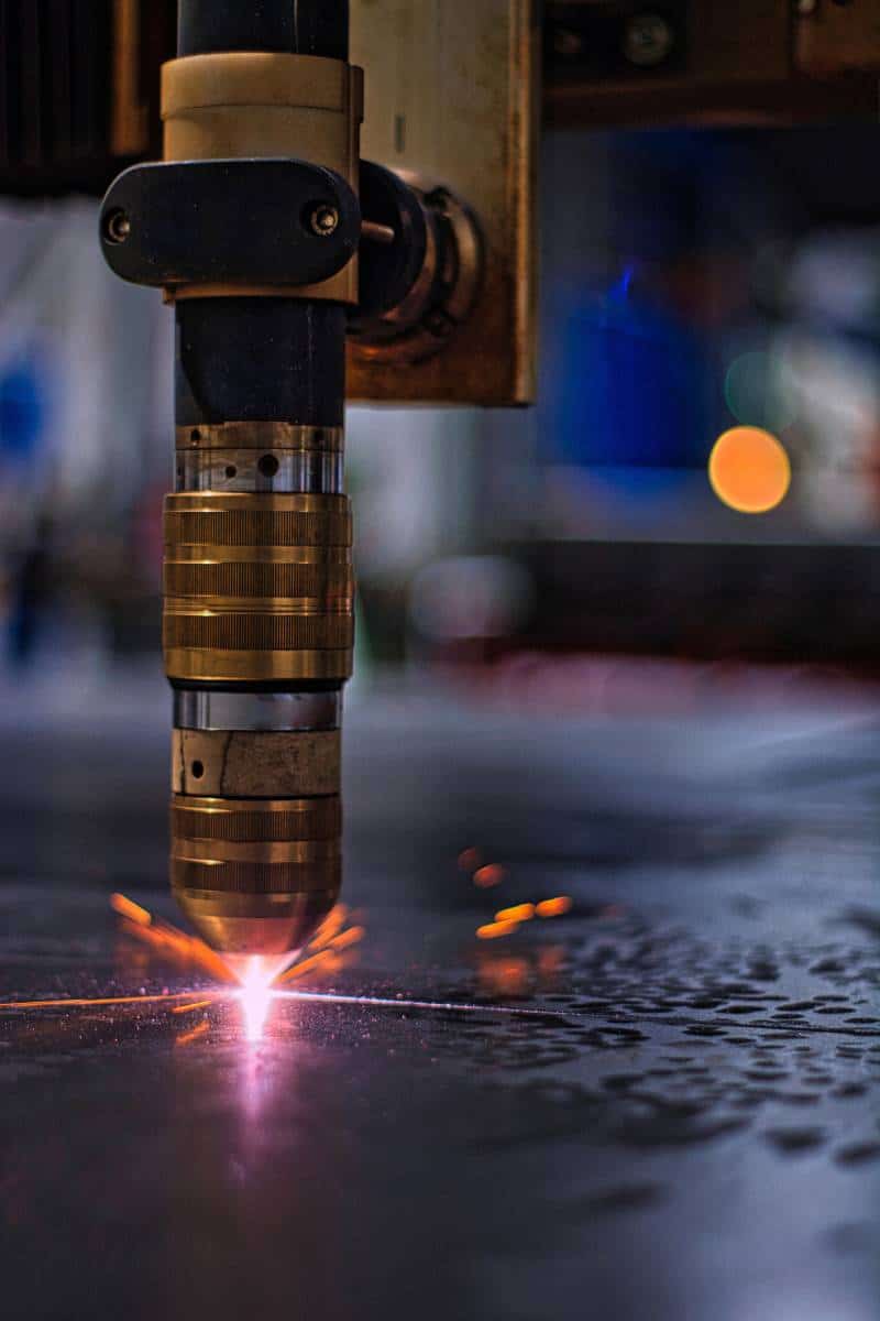 Industrial laser cutting metal with sparks.